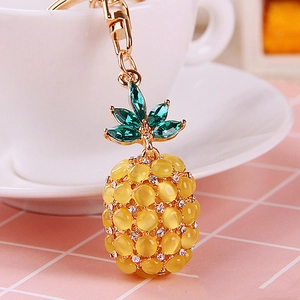 Close-up of cat eye stone pineapple keychain with gold plating and rhinestones