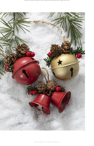 Detail of red and gold Christmas bells with pine cones and red berries on snow