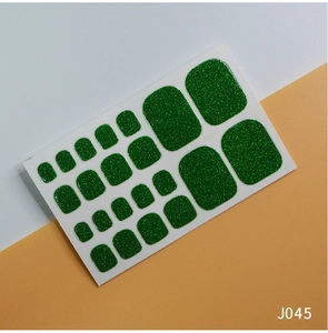 Detail of green glitter toe nail stickers J045 showing sparkling texture and various sizes