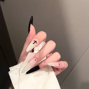 Long stiletto press-on nails featuring black cross designs and minimalist dots on a grey background