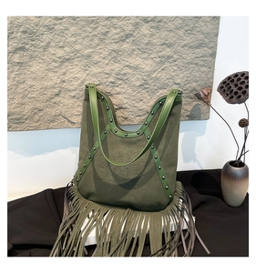 Detail of army green bohemian shoulder bag with sun embroidery, silver studs and fringes