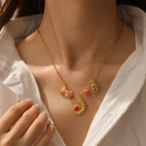 Gold-plated stainless steel seashell necklace with star and conch charms on a paperclip chain