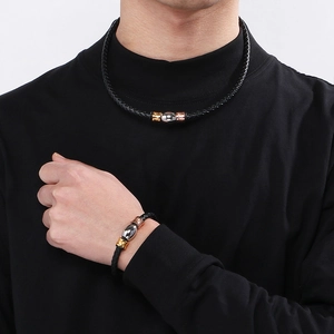 Detail of men's black braided leather necklace and bracelet set with tricolor beads