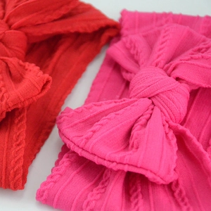 Detailed view of red and rose red knit texture baby headbands with bow accents
