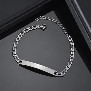 Close-up of polished silver Figaro chain bracelet with blank rectangular ID metal plate