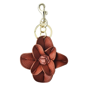Brown leather camellia flower keychain with gold metal hook and ring on white background