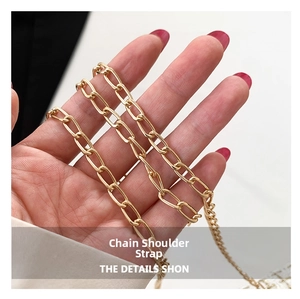 Close-up of polished light gold metal chain strap showing oval links and mirror finish