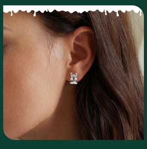Close-up of S925 sterling silver reindeer stud earring worn with festive holiday accents
