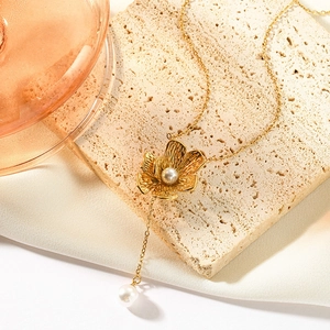 Elegante collana a Y con fiori dorati e perle su base in pietra e vetro champagne