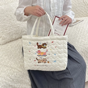 Detailed embroidery of three cute cats on a white quilted heart-textured handbag