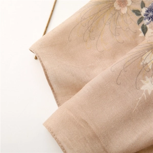 Detailed macro shot of vintage floral pattern on beige cotton linen textured scarf