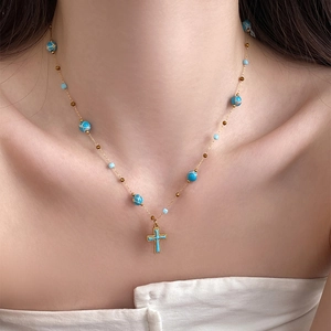 Bohemian style cross pendant necklace with blue stone beads on a golden chain