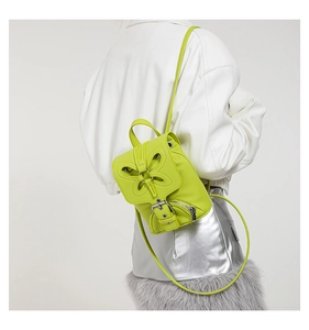 Détail du mini sac à dos vert fluo en cuir grainé avec applique papillon et boucles métalliques