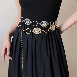 Vintage metal waist chain with gold links and pearl charms on model over black dress