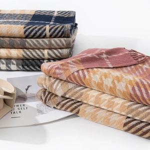 Stack of colorful plaid scarves in blue, beige and pink with soft cashmere texture