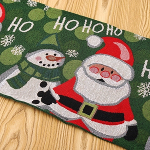 Close-up of Christmas table runner with Ho Ho Ho knit pattern on light wood background