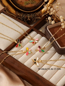 Detailed close-up of a 18K gold-plated dragonfly pendant with colorful enamel wings