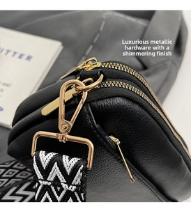 Detail of black litchi grain PU leather bag with golden zipper and geometric woven strap