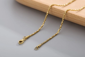 Macro shot of gold snake chain with lobster clasp highlighting metal texture and details