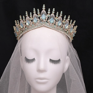 Close-up of golden bridal tiara with blue pear-shaped stones and rhinestones on veil