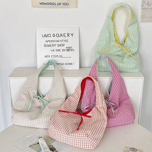 Detailed display of plaid canvas tote bags in green, pink, red, and beige colors