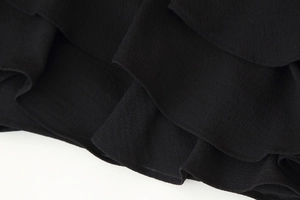 Detailed macro view of black chiffon tiered ruffles and fine fabric texture on a skirt