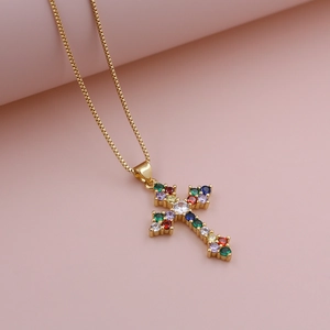 Close-up of golden cross pendant necklace featuring colorful pavé zircon stones and a box chain