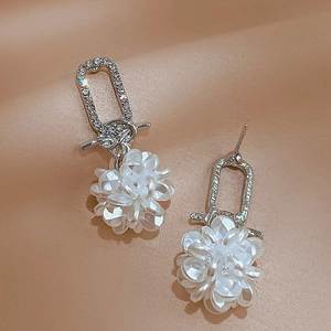 Detail of silver floral drop earrings with white petals and sparkling rhinestones