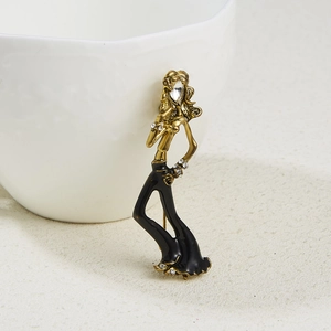 Detail of ballet dancer brooch with gold alloy, black enamel and inlaid rhinestones