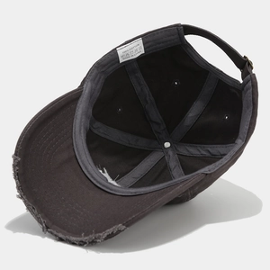 Detail view of 100% cotton inner lining and distressed edge of dark grey baseball cap