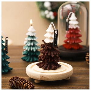 Close-up of handmade Christmas tree candle in glass dome with cozy festive decor