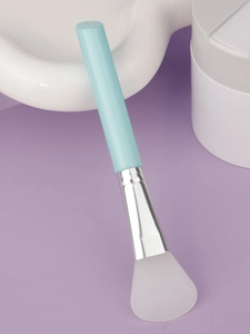 Detail of soft silicone mask brush with light blue handle and flat fan-shaped white head