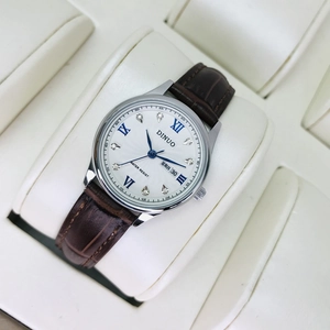 Macro shot of silver steel watch dial with roman numerals and calendar date window