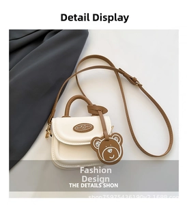 Detail of mini crossbody bag in cream leather with brown handle and cute bear logo charm