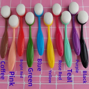 Detailed view of ten colorful oval foundation brushes on a pink grid background