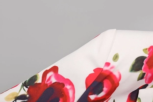 Gros plan détaillé de l'imprimé floral rose rouge et des coutures sur le tissu blanc