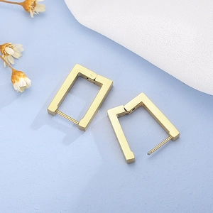 Close-up of golden rectangular geometric earrings with a secure hinged clasp closure