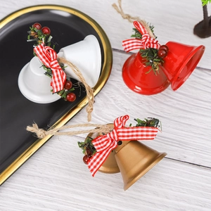 Close-up of red, gold, and white Christmas bells with bows on a rustic wood surface