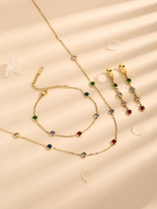 Luxurious gold jewelry set with colorful crystals including necklace, bracelet and earrings