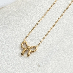 Gros plan détaillé du collier pendentif nœud plaqué or 18 carats avec finition polie