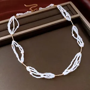 Elegant multi-strand glass pearl beaded necklace with gold metal accents on a tray