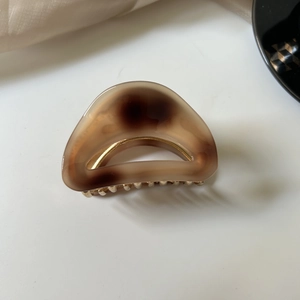 Detailed view of medium brown acetate hair claw clip with shell pattern texture