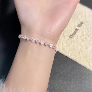 Elegant silver bracelet with pink and white zircon crystals worn on a woman's wrist