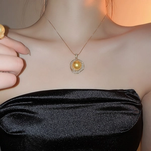 Gros plan d'un ensemble collier et bague en perles dorées sur un haut en soie noire