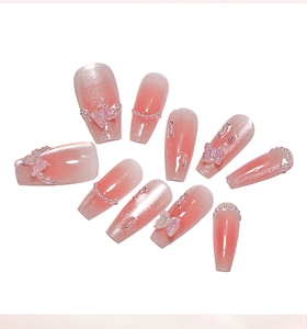Detailed view of blush pink cat-eye press-on nails decorated with 3D butterflies and pearls