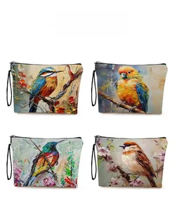 Vue détaillée de quatre pochettes avec imprimés oiseaux et fleurs, zips et anses noirs