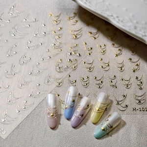 Golden starry sky nail art decals featuring meteors and stars on pastel gradient nails