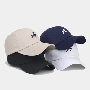 Detailed stack of cotton baseball caps with 3D letter embroidery in four colors
