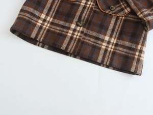 Close-up of brown plaid wool coat showing sleeve cuffs, buttons, and pocket details