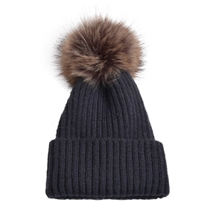 Dettaglio del berretto in maglia a coste grigio scuro con un grande pompon in ecopelliccia
